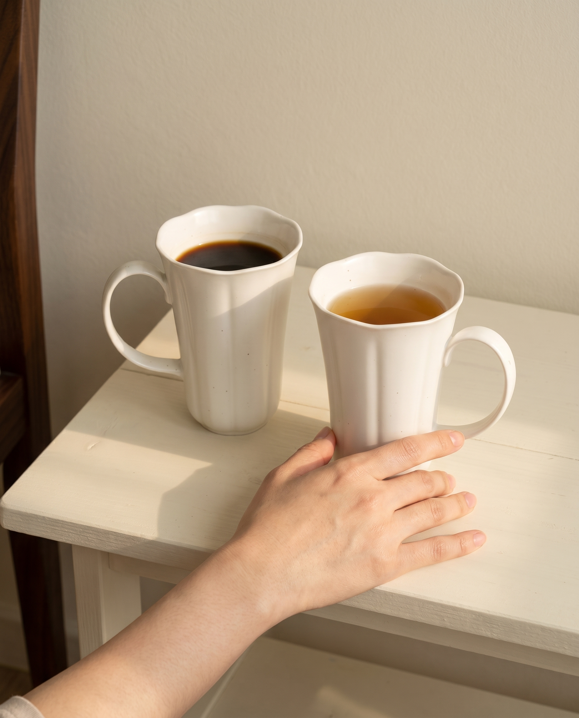 Blooming mug and plate set by Insoil — both mugs poured for the small dessert hour, a hand at rest beside them