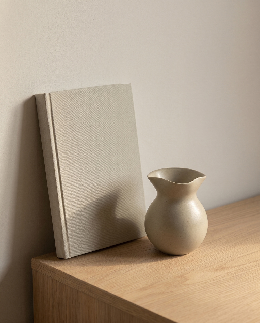 OROS U vase by NR Ceramics beside a closed clothbound hardback book for size reference