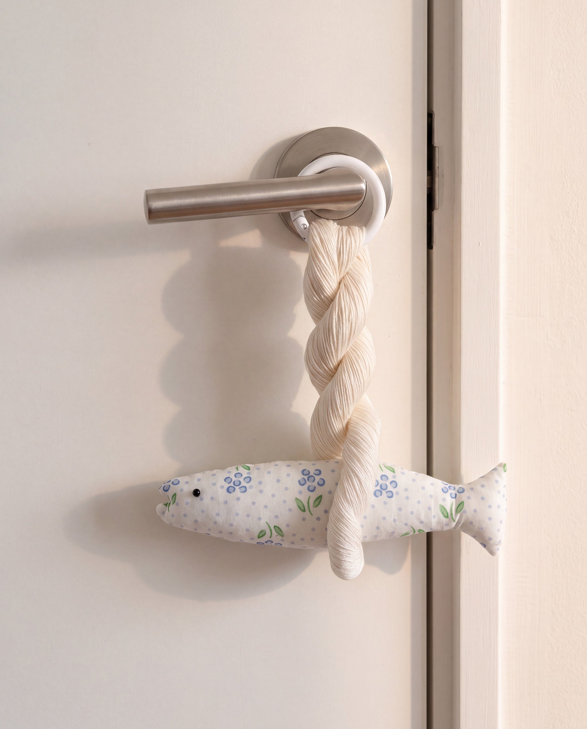 Blair good luck pollack ornament by lemonbaseball livingclub, ring clasp closed around a door lever