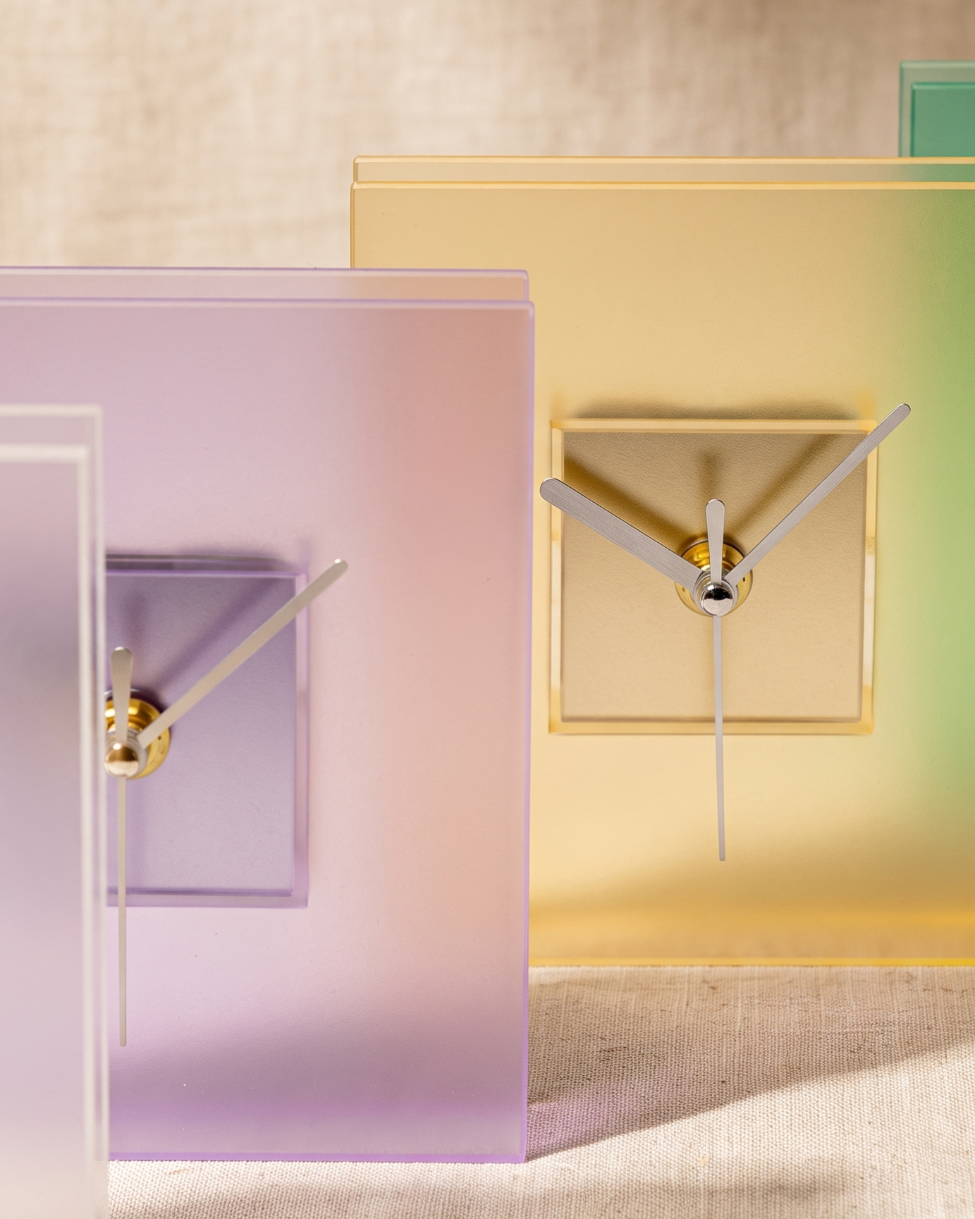 Block clock by APTONE, close view of the raised centre block, silver hands and brass hub across the purple and yellow colourways