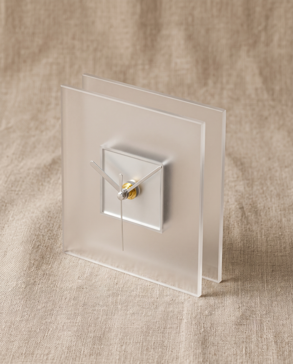 Block clock by APTONE in frosted white, three-quarter view on natural linen