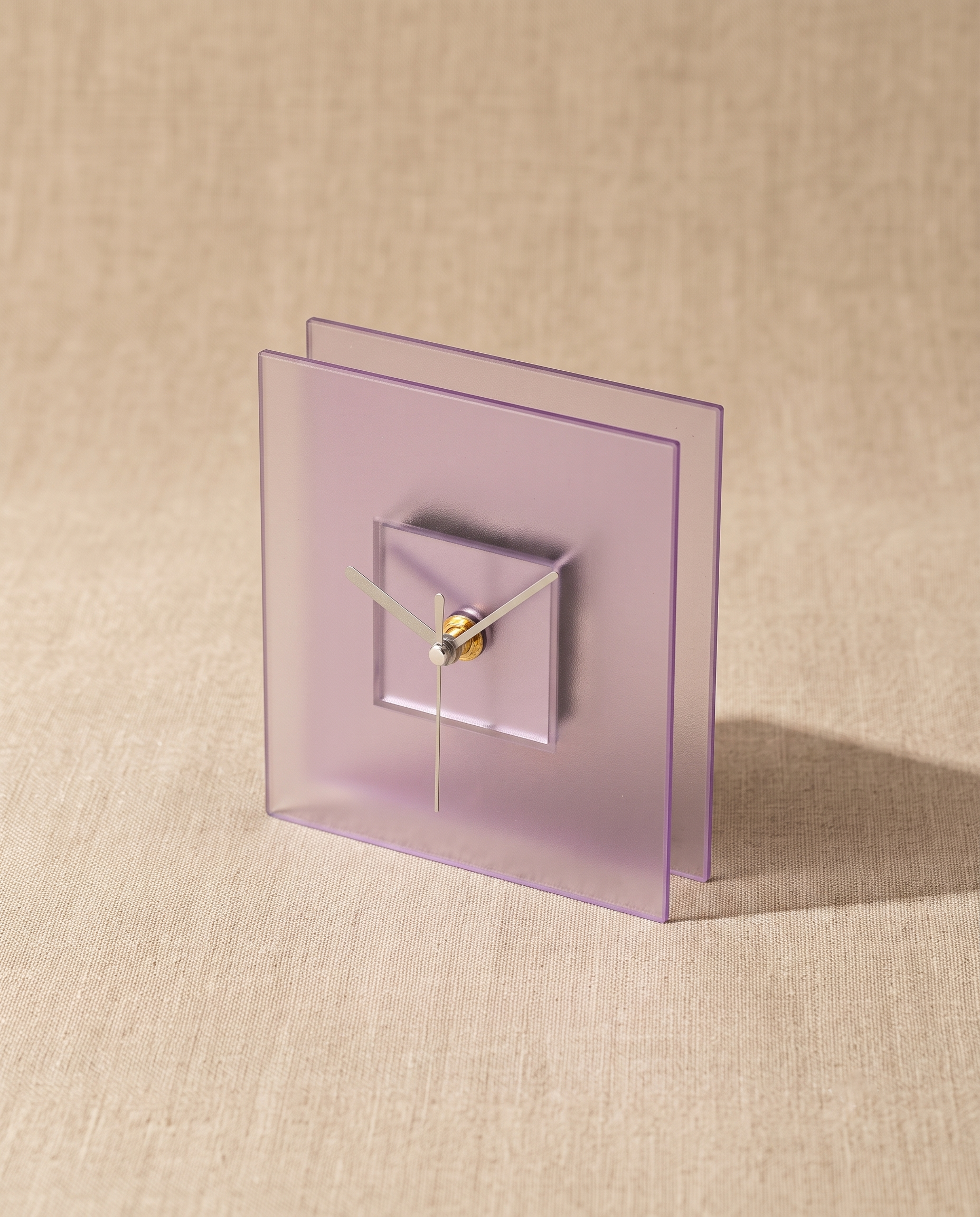 Block clock by APTONE in frosted purple, three-quarter view on natural linen