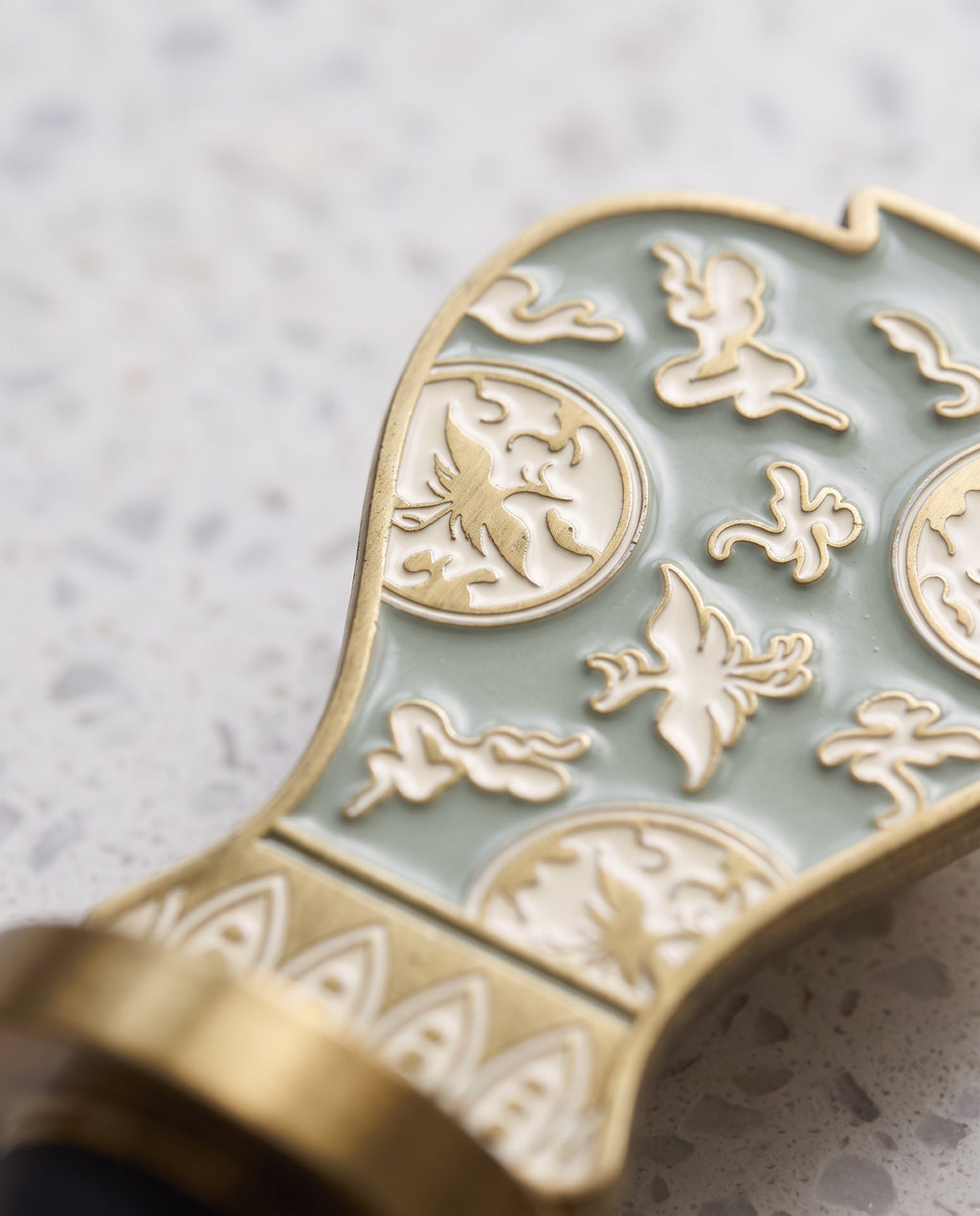 Celadon in the house wine stopper by Mimidar, macro of the crane roundel in raised brass and enamel