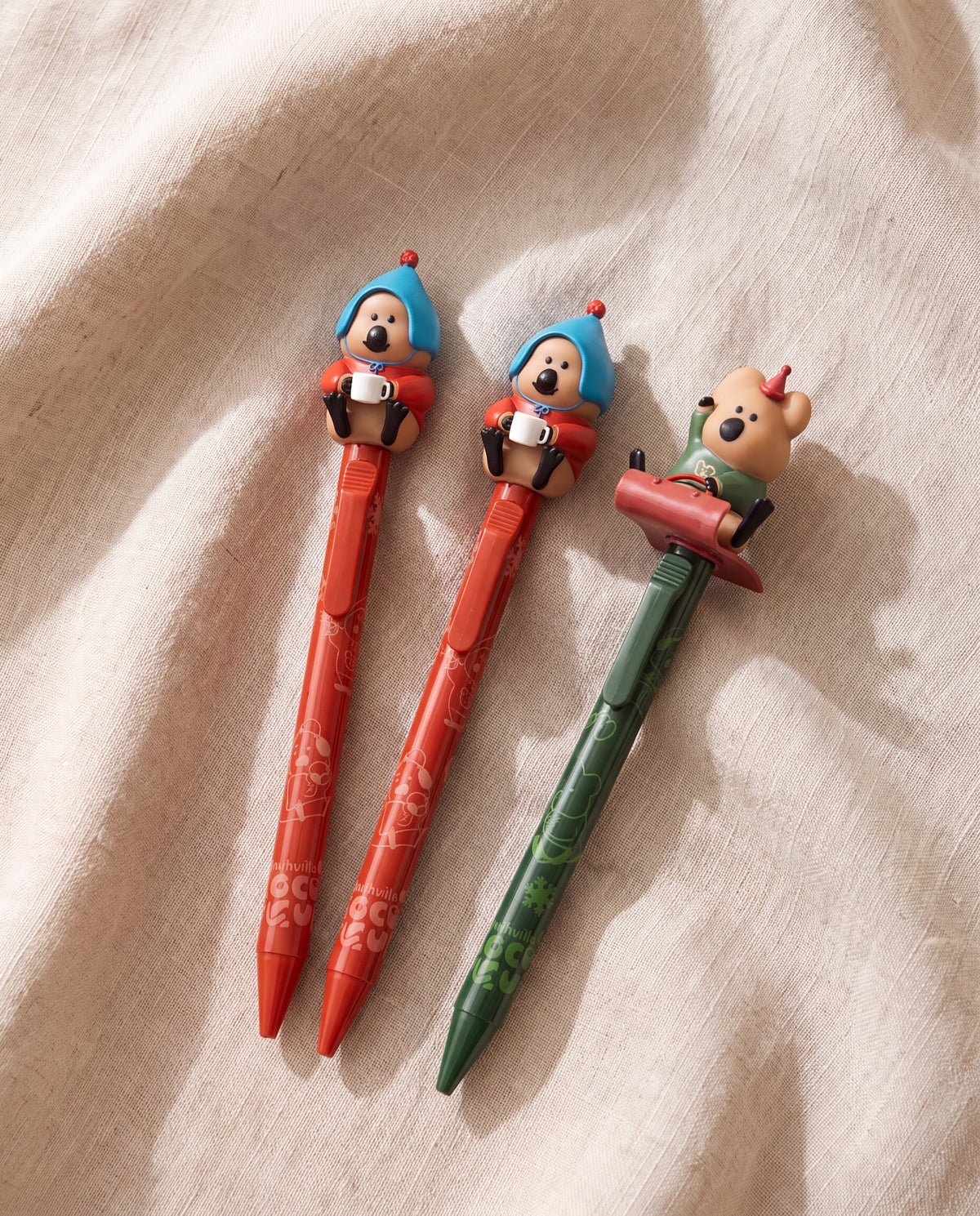 Cococup clicky pens by Dinotaeng, set of three on beige linen