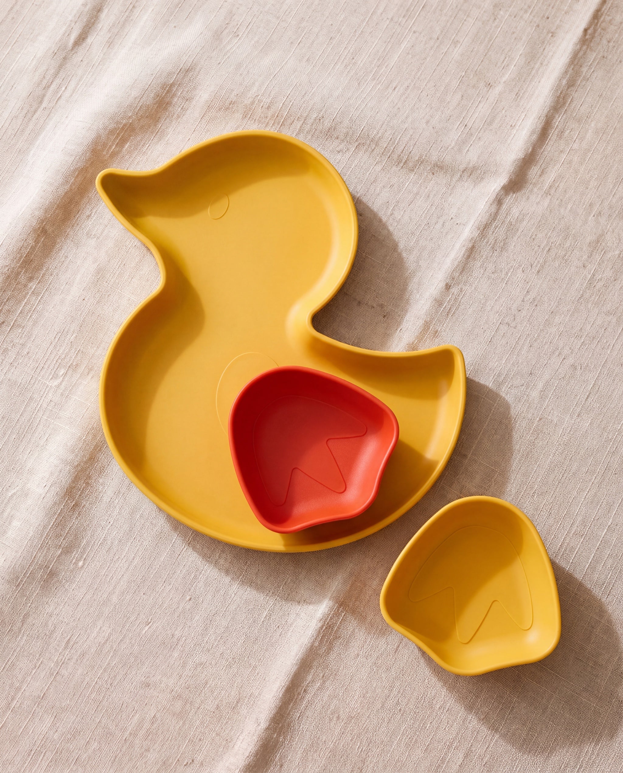 Ducky plate and Webby bowls by ceriz, all three pieces together on beige linen