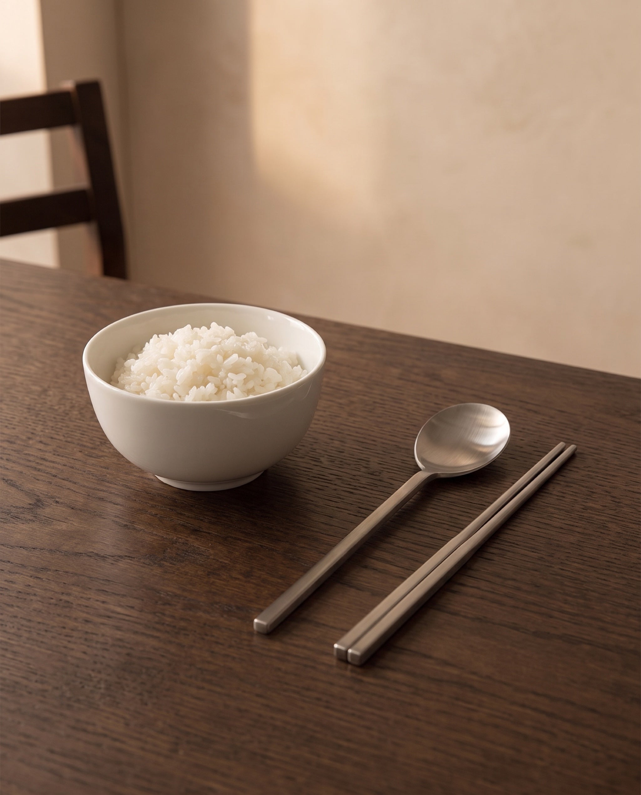 Essential dinner cutlery by NR Ceramics, laid beside a white porcelain bowl of rice