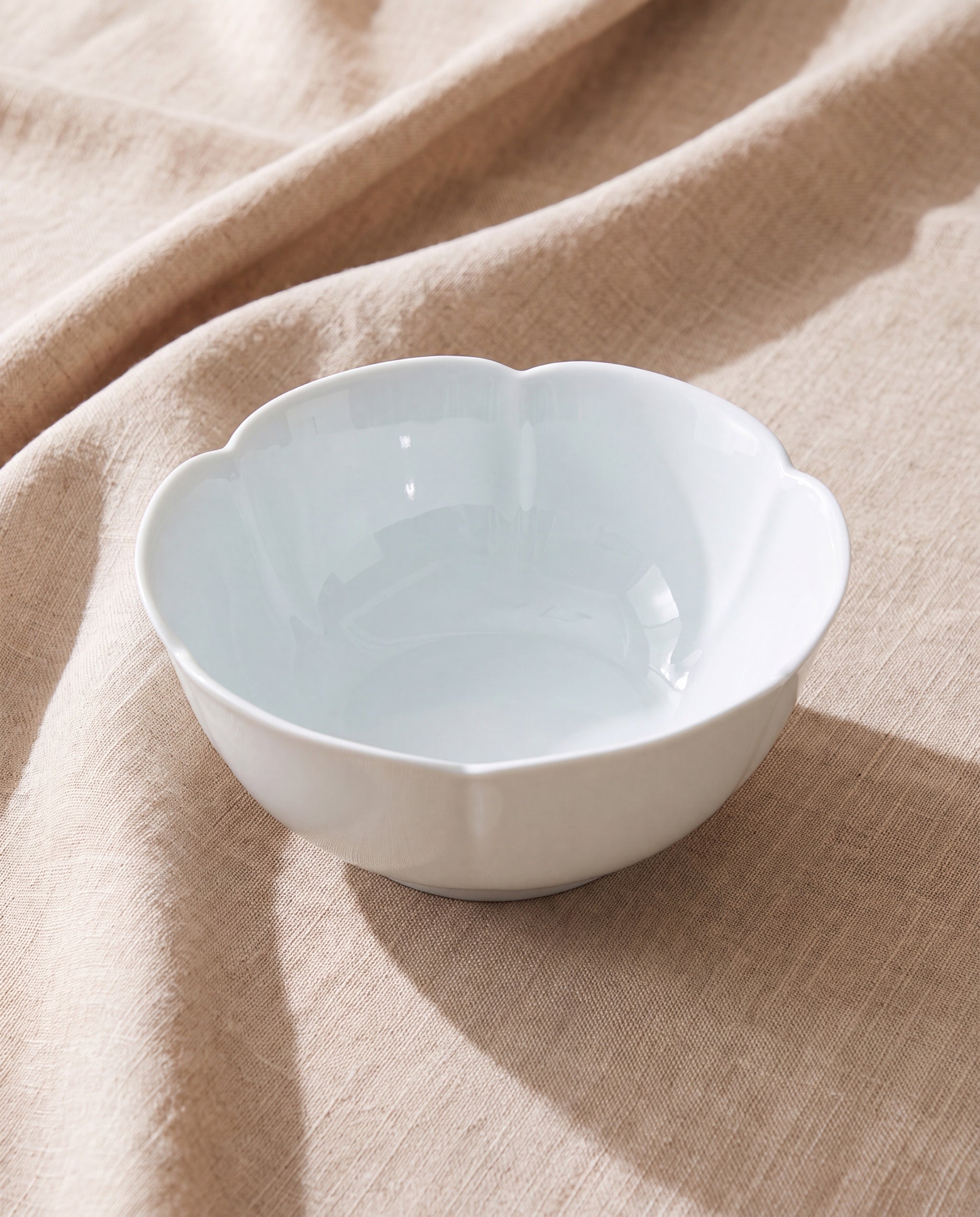 Floom bowl L by Mujagi, gloss white porcelain on beige linen