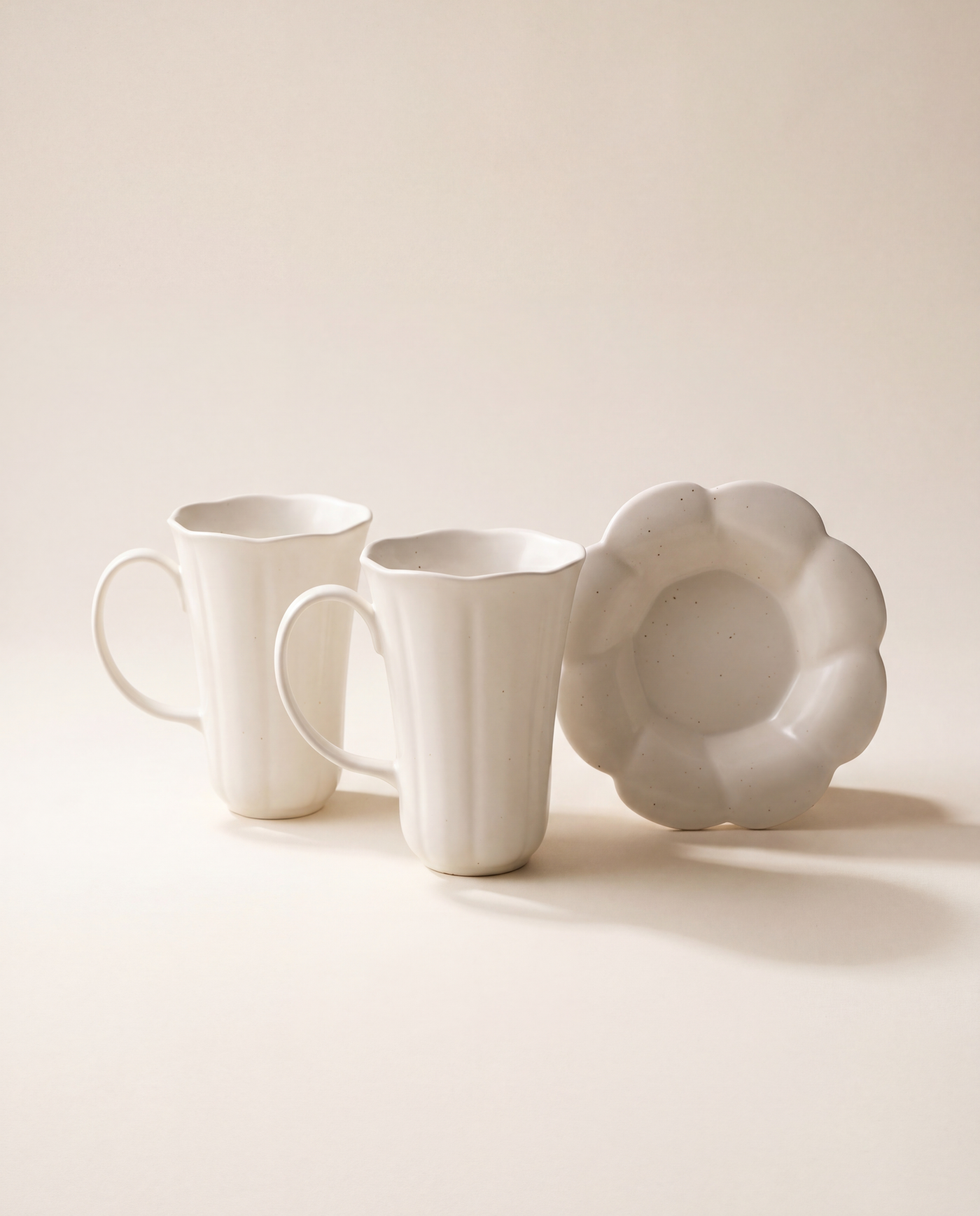 Blooming mug and plate set by Insoil — hand-formed semi-matte off-white ceramic, on a hanji-cream backdrop