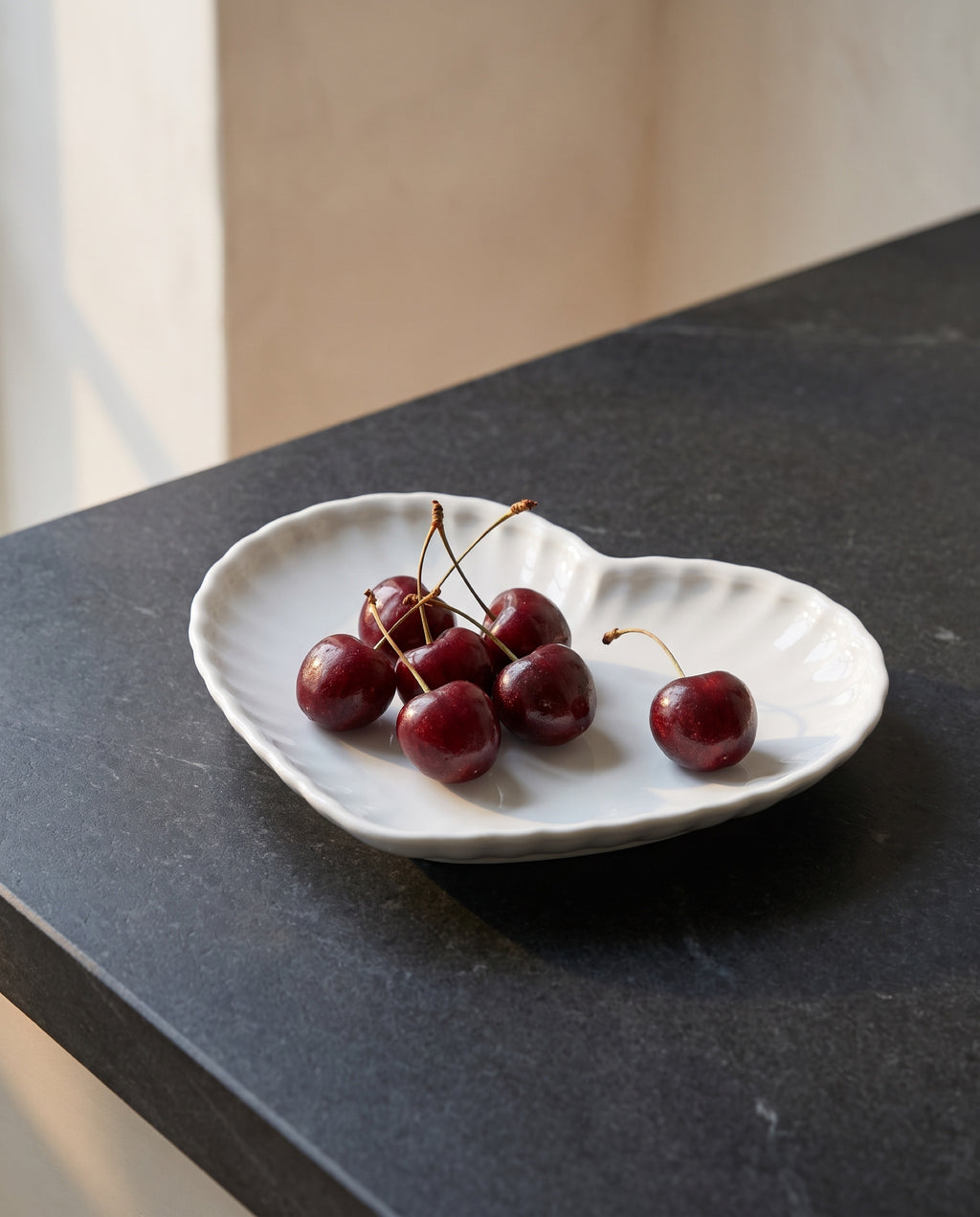 Heart plate by Mujagi, holding a handful of cherries
