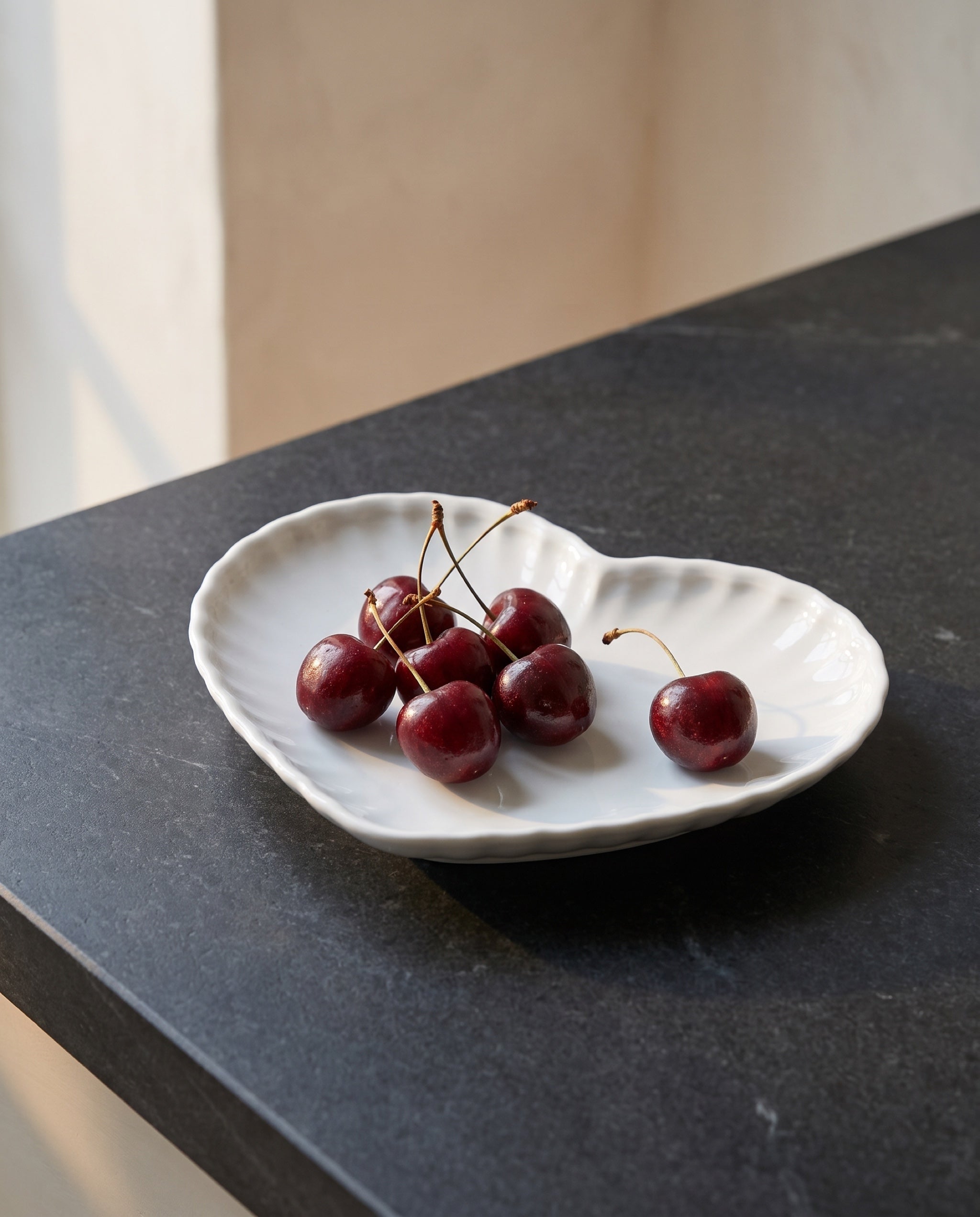 Heart plate by Mujagi, holding a handful of cherries