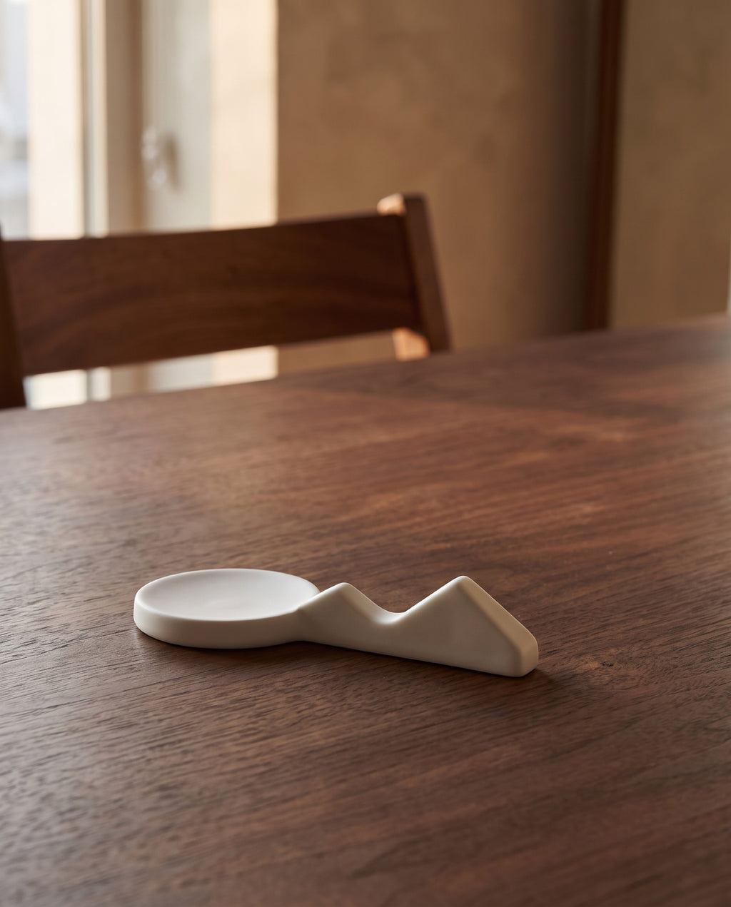 Land scape cutlery rest by Mujagi, on a walnut dining table before dinner
