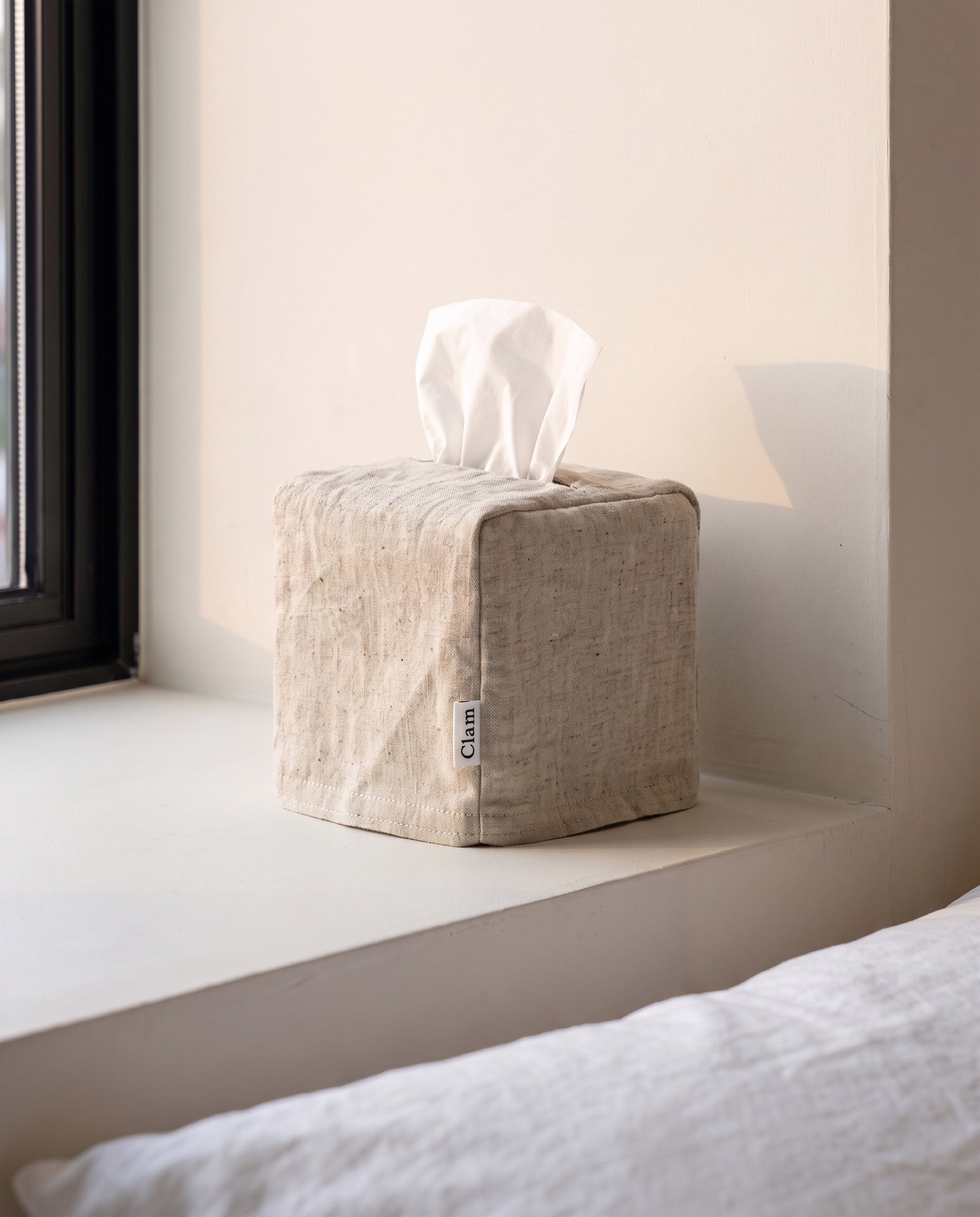Linen tissue cover by Clam in Natural, undyed oatmeal flax, on a bedroom window sill