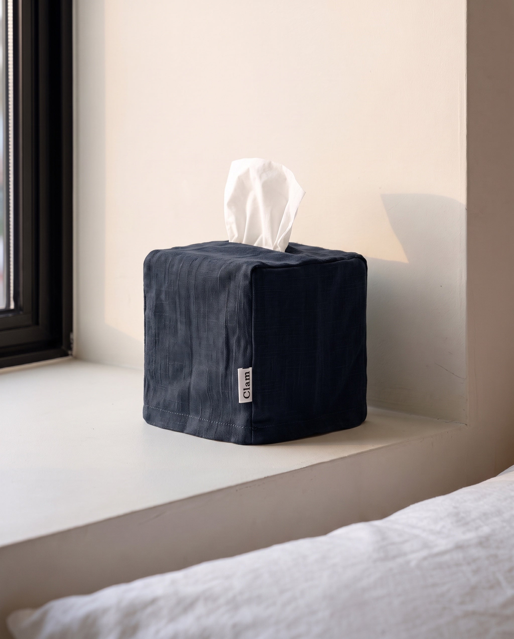 Linen tissue cover by Clam in Navy, on a bedroom window sill