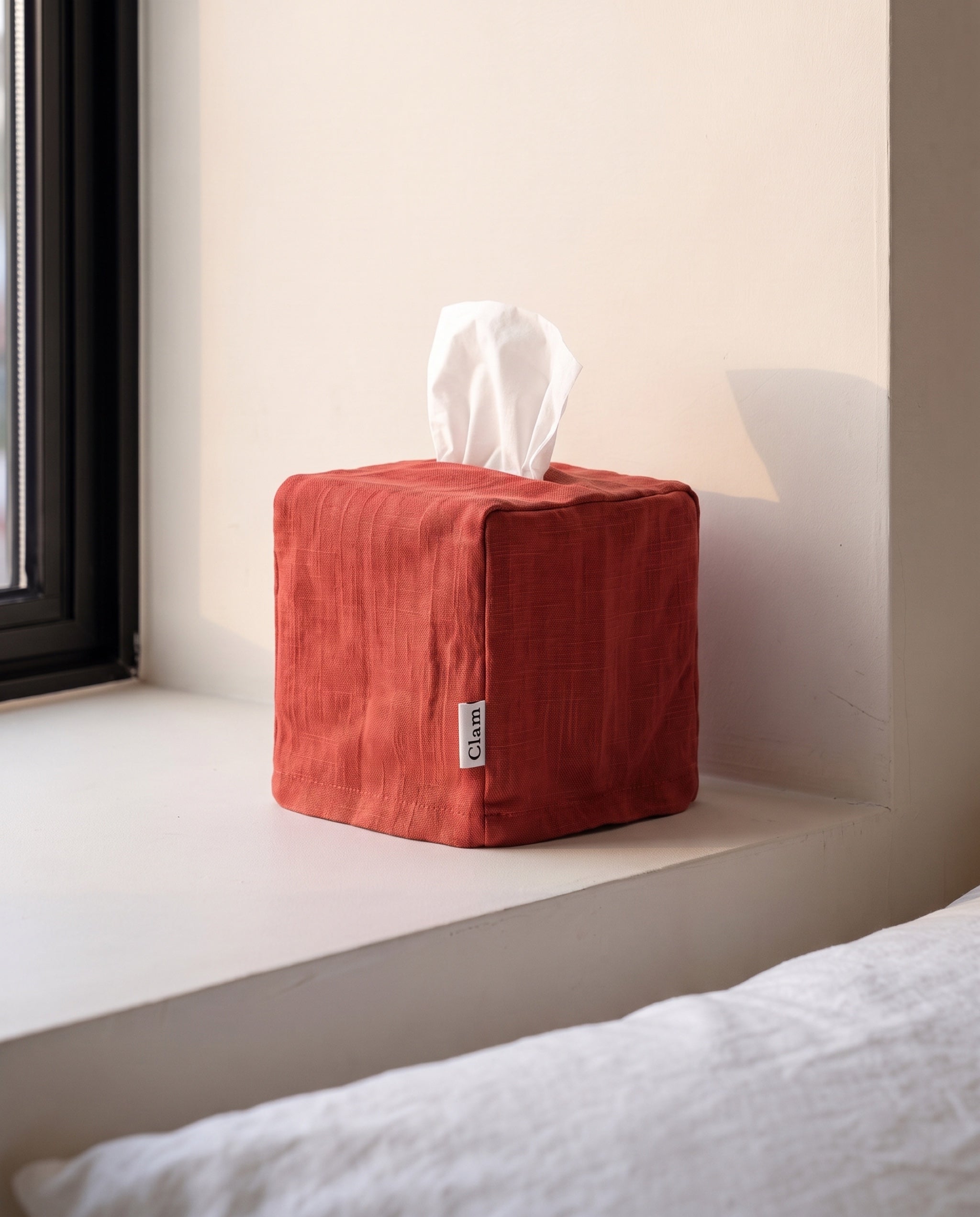 Linen tissue cover by Clam in Scarlet, on a bedroom window sill