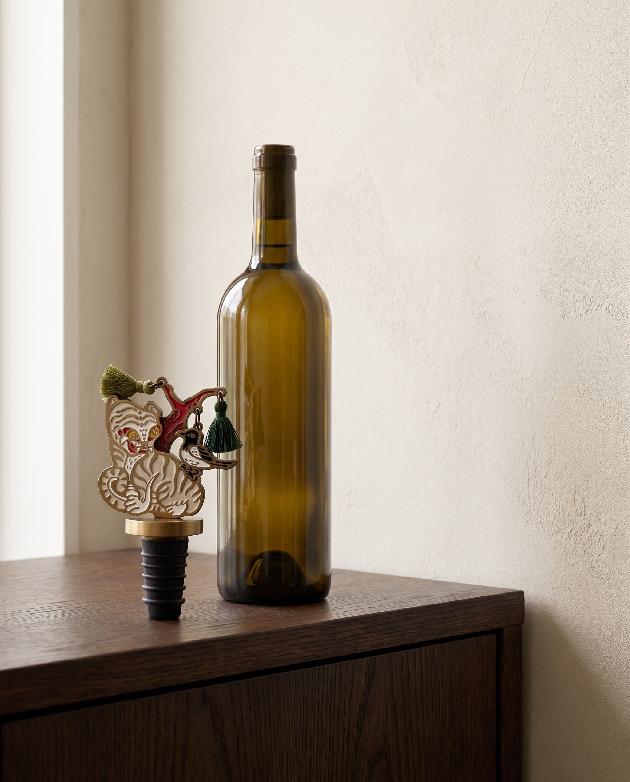 Magpie and tiger wine stopper by Mimidar, scale reference beside a 750ml wine bottle