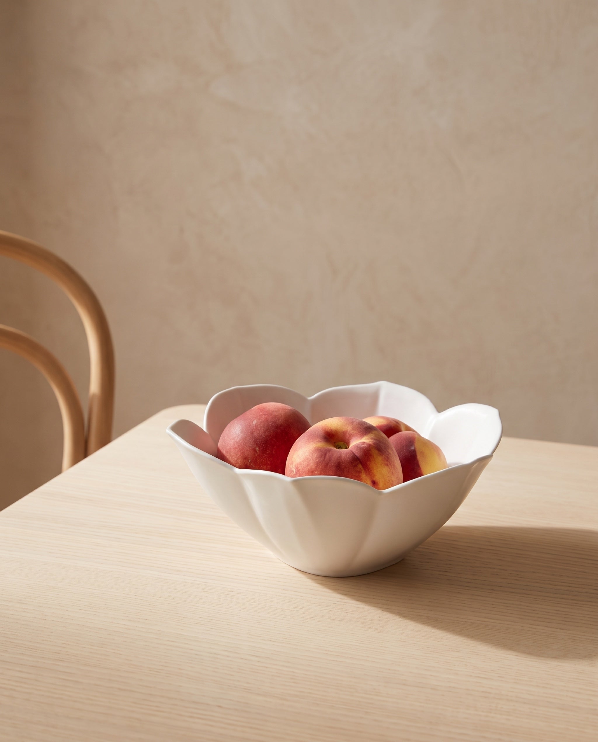 Petal bowl by Mujagi, holding three ripe peaches