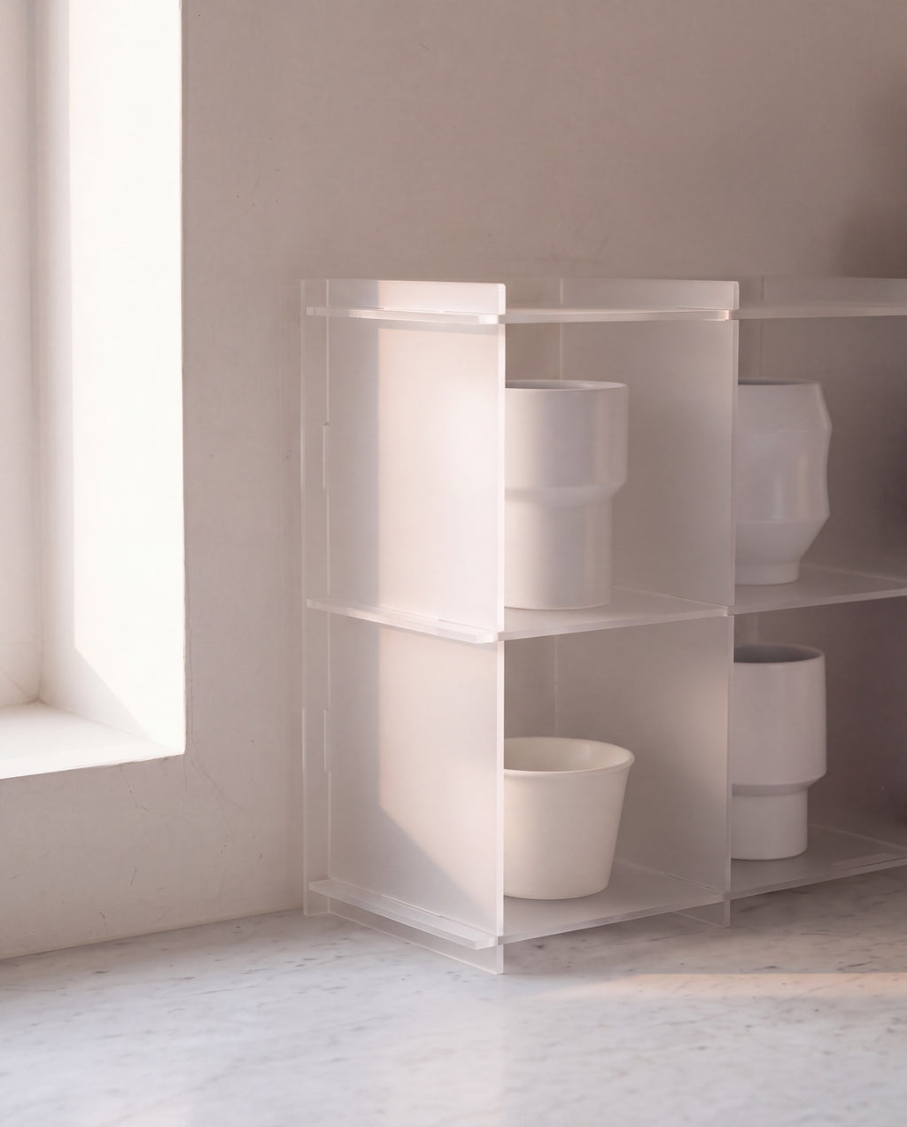 Cups seen through the frosted acrylic side panel of the Soyojang shelf