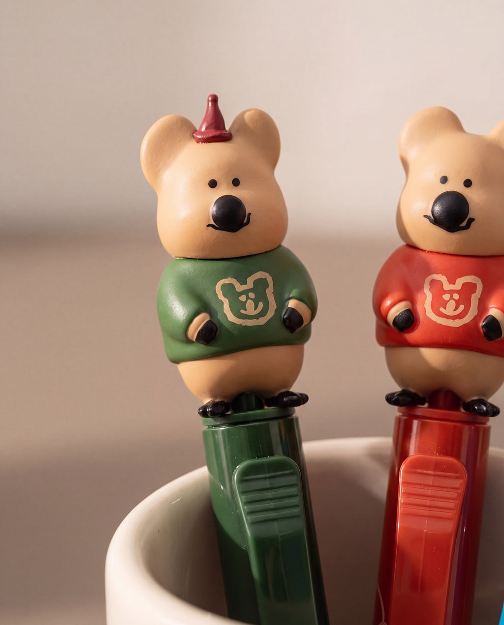 Quokka in School figure pen by Dinotaeng, close-up of the molded quokka figures and the printed bear face on the sweatshirt