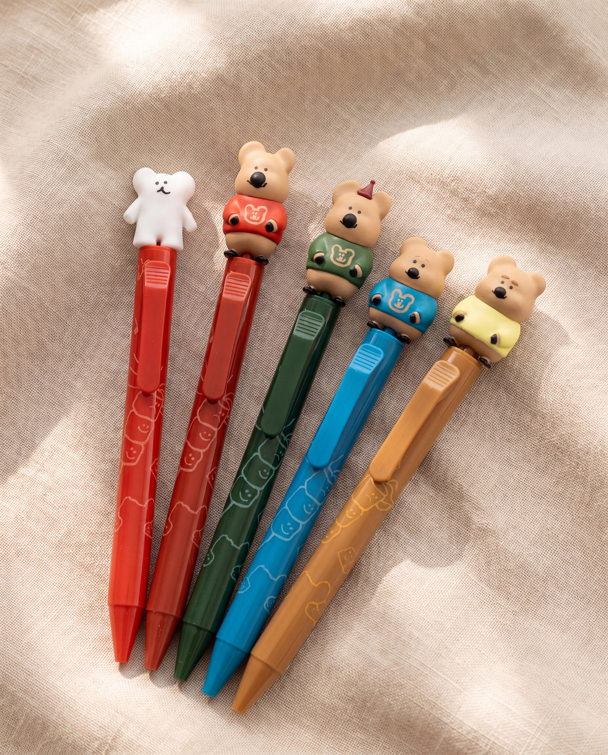 Quokka in School figure pen by Dinotaeng, all five pens on warm beige linen