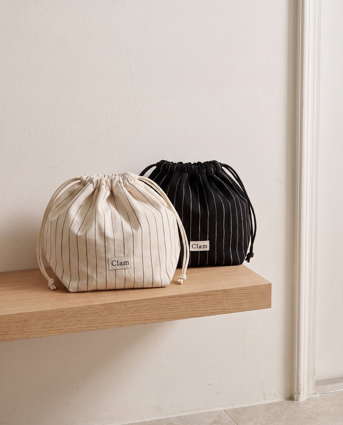 String pouch set of two by Clam, Natural stripe and Natural black stripe side by side