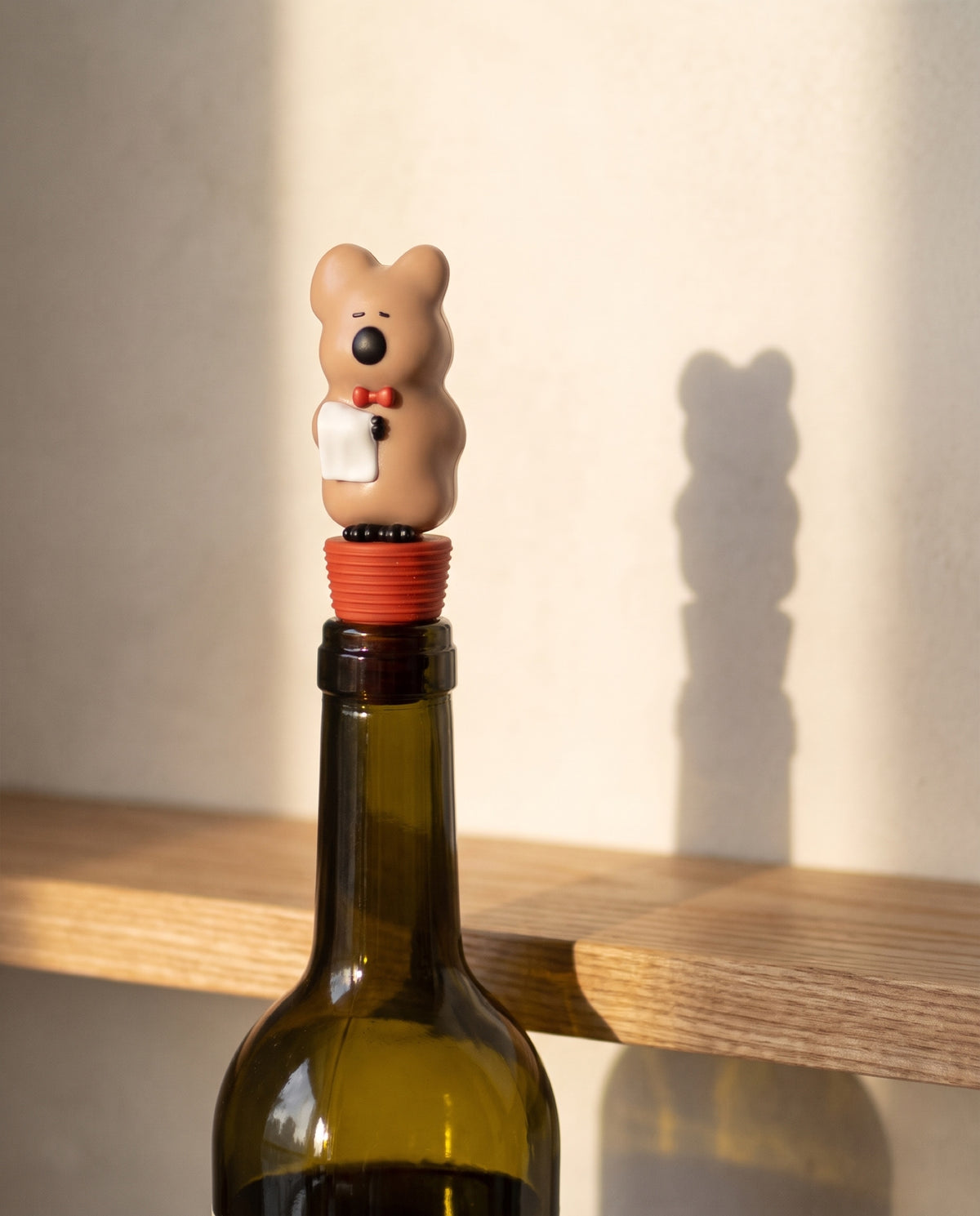 Quokka wine stopper by Dinotaeng, seated in the neck of an opened bottle