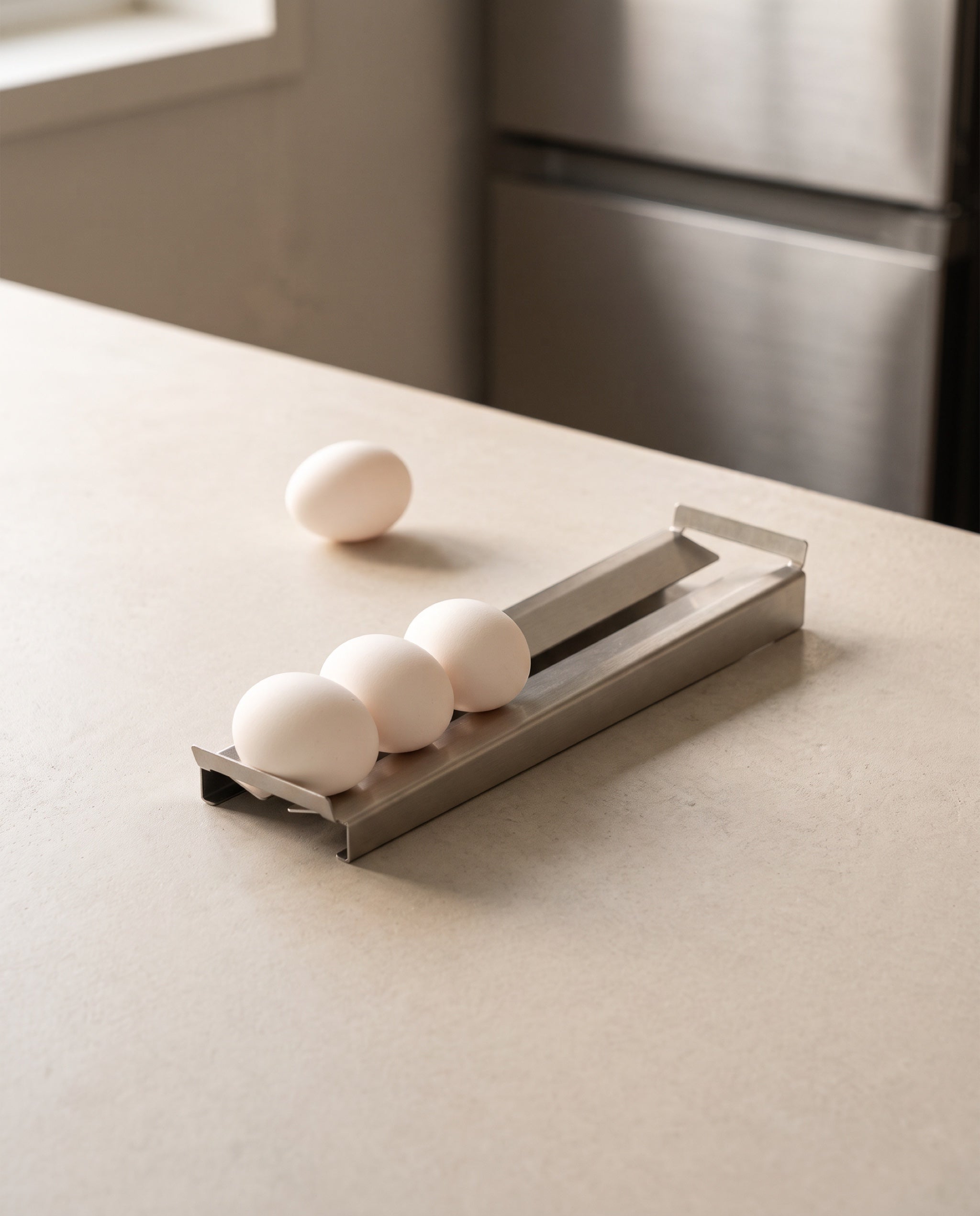 Slope egg tray by TactileEveryday, eggs gathered at the low end with one taken