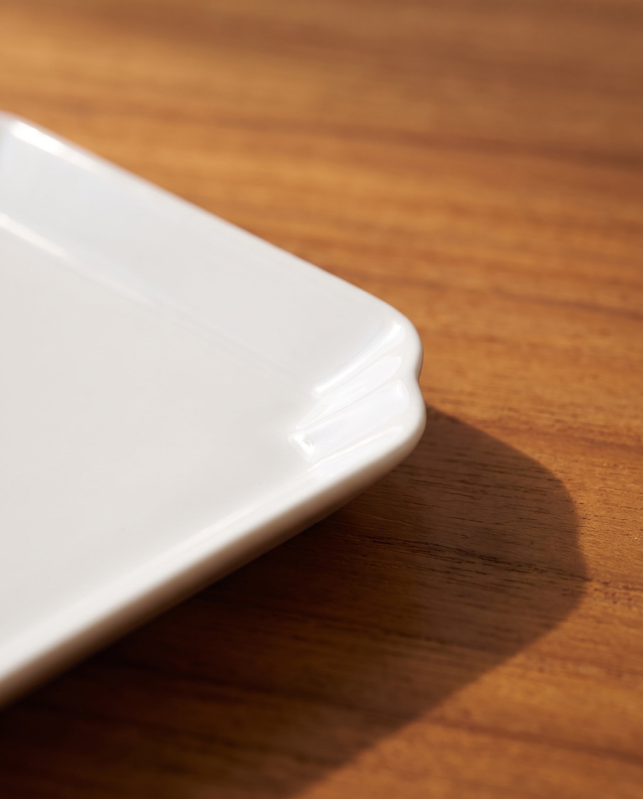 Square plate by Mujagi, the rim folding back at the corner in a stepped notch
