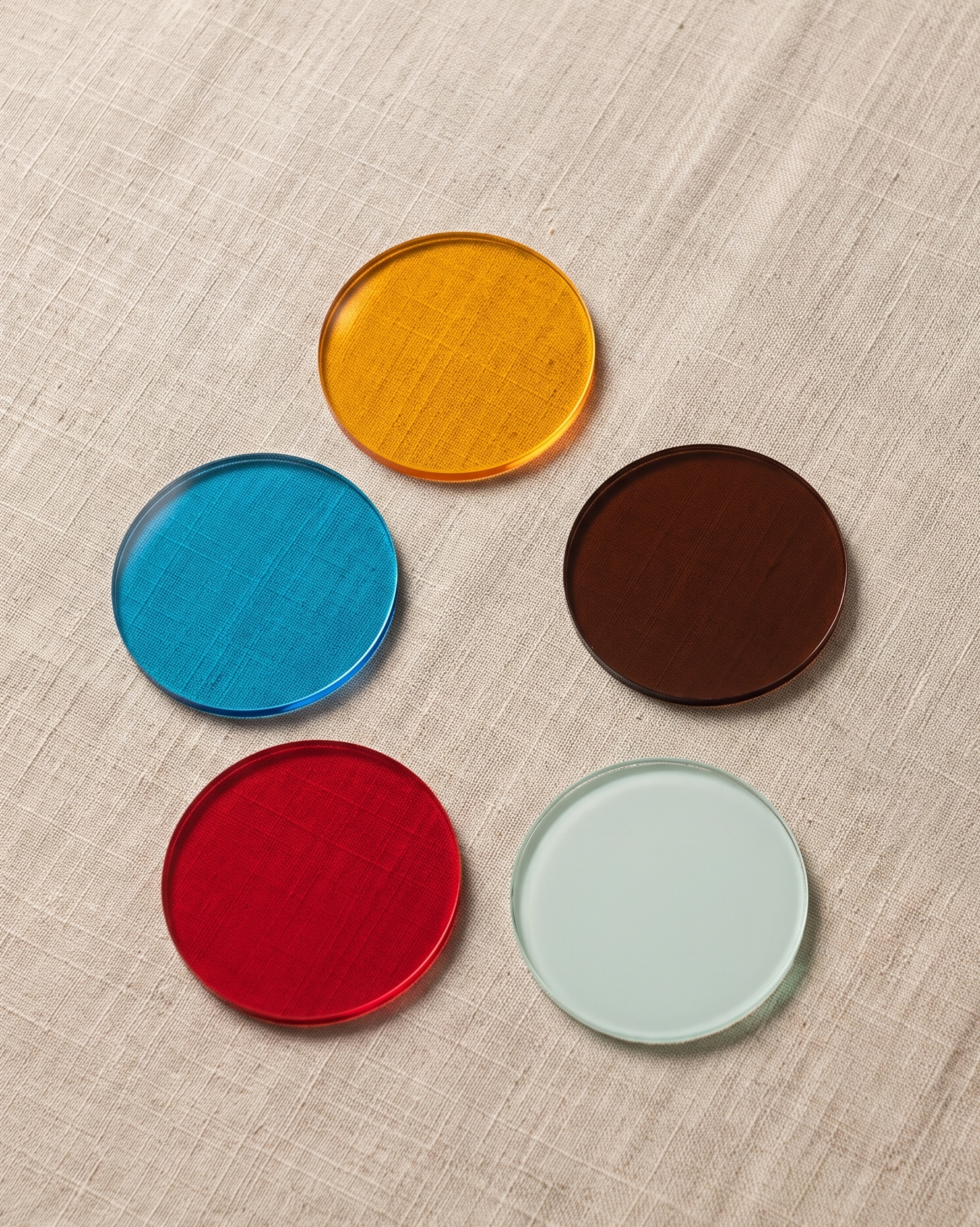 Rainbow coaster by APTONE, all five acrylic discs laid out on linen