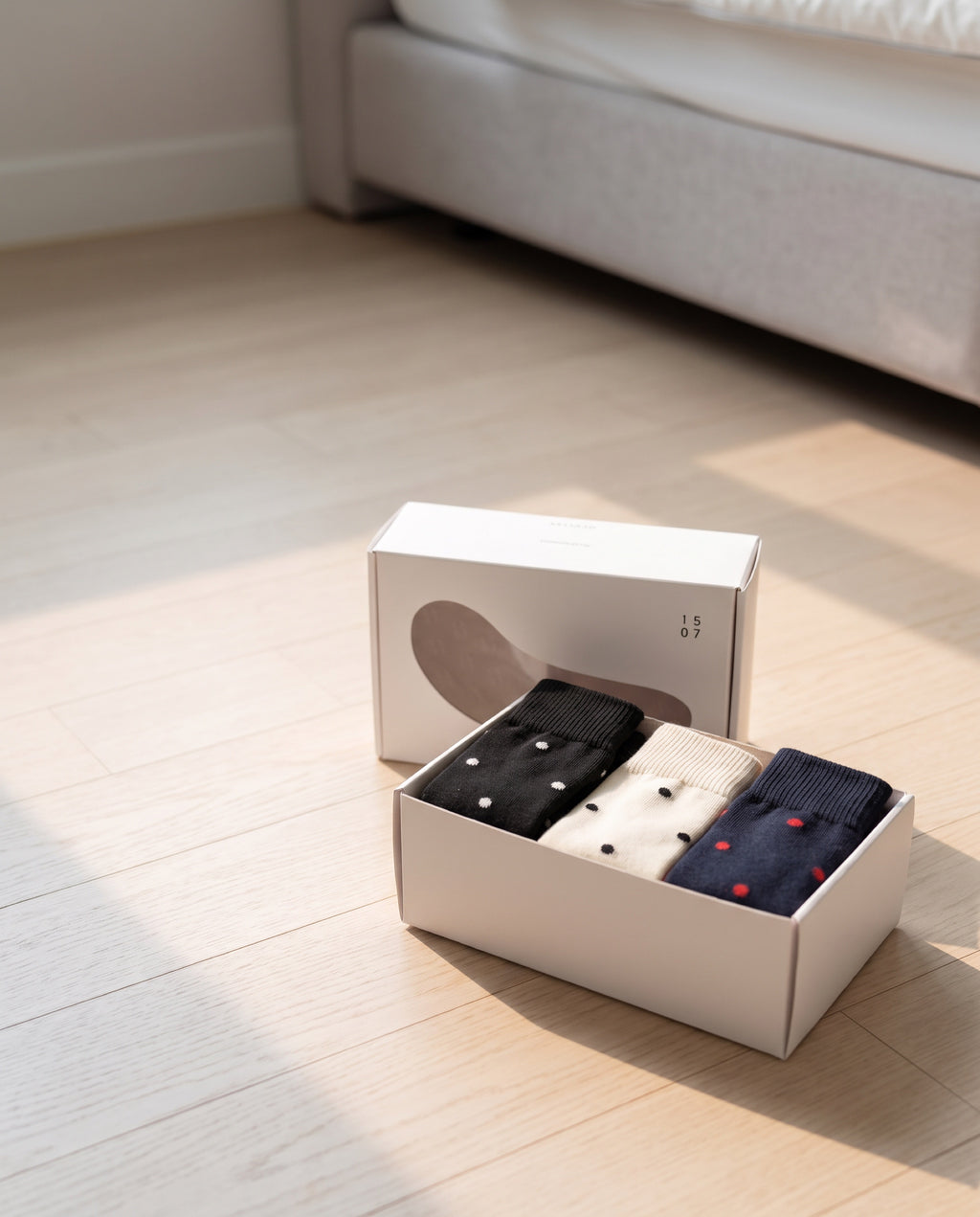Unisex dot basic socks by 1507, the box opened on a bedroom floor, lid leaning behind it