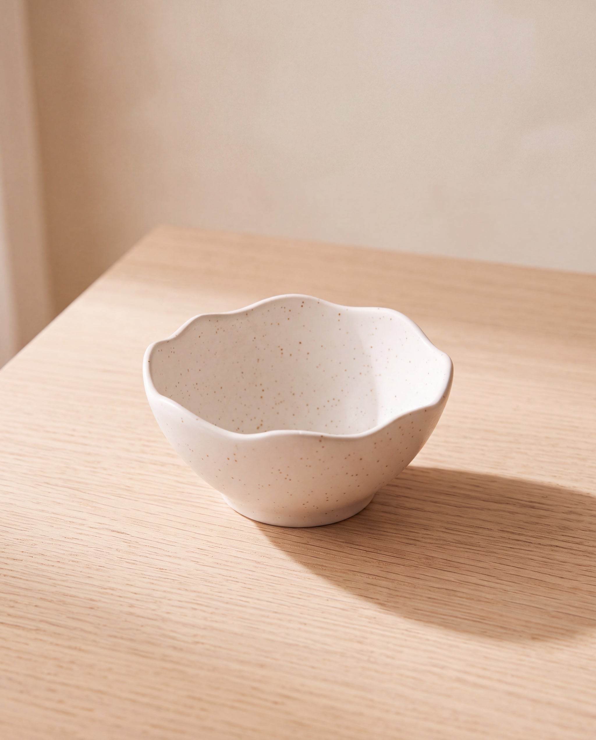 Wave topping bowl by Yido Pottery, empty on a pale oak table