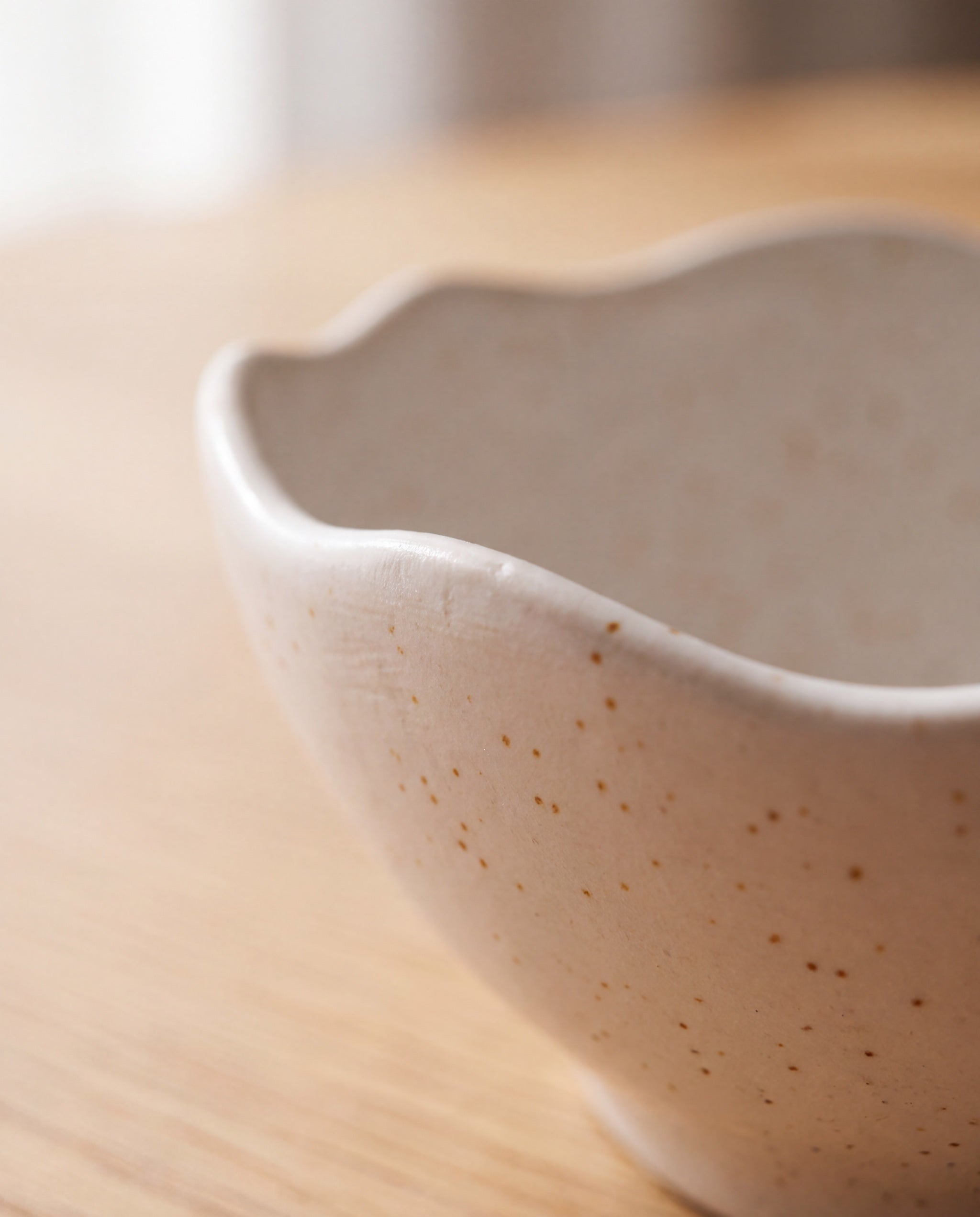 Wave topping bowl by Yido Pottery, detail of the wavy rim and speckled glaze