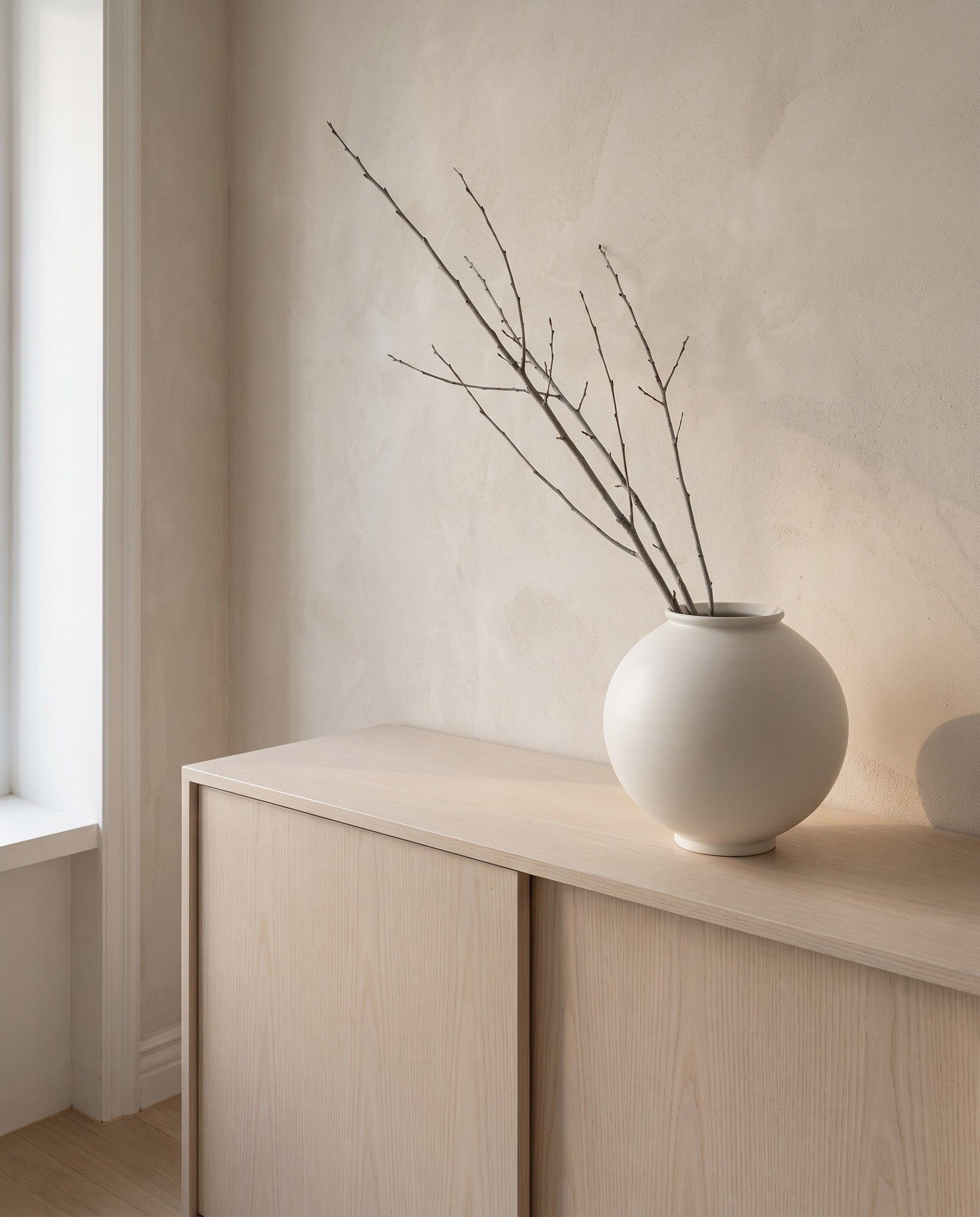 Bare winter branches set in the white porcelain moon jar